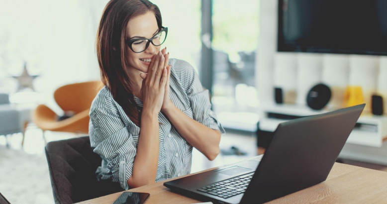 Happy woman finds the perfect IT job online, sitting at her desk