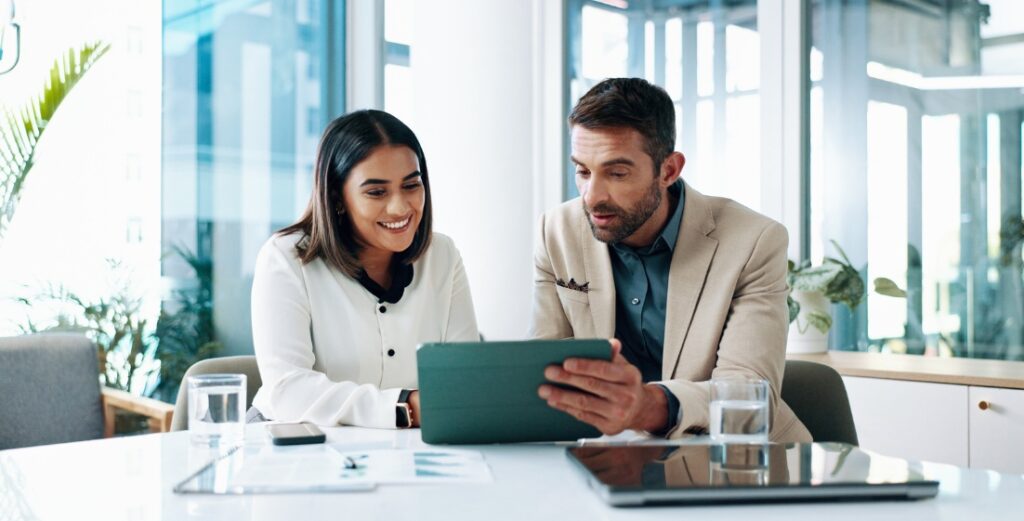 Two professionals reviewing data on tablet in modern office