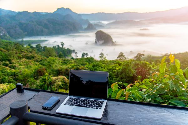 a laptop on a balcony in a tropical location