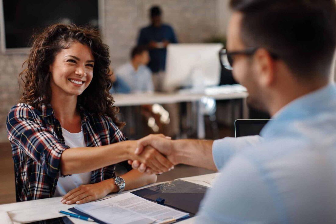 woman shaking hands with a man - recruiting strategy applied in interview