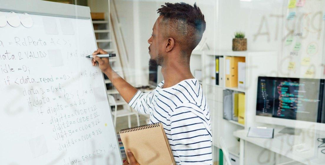 Man working on a project on a dry-erase board
