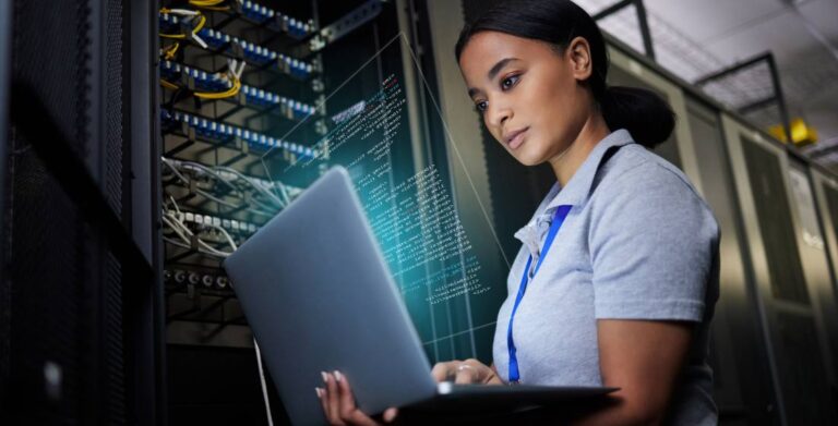 Laptop, network and data center with a black woman it support engineer working in a dark server room. Computer, cybersecurity and analytics with a female programmer problem solving or troubleshooting.