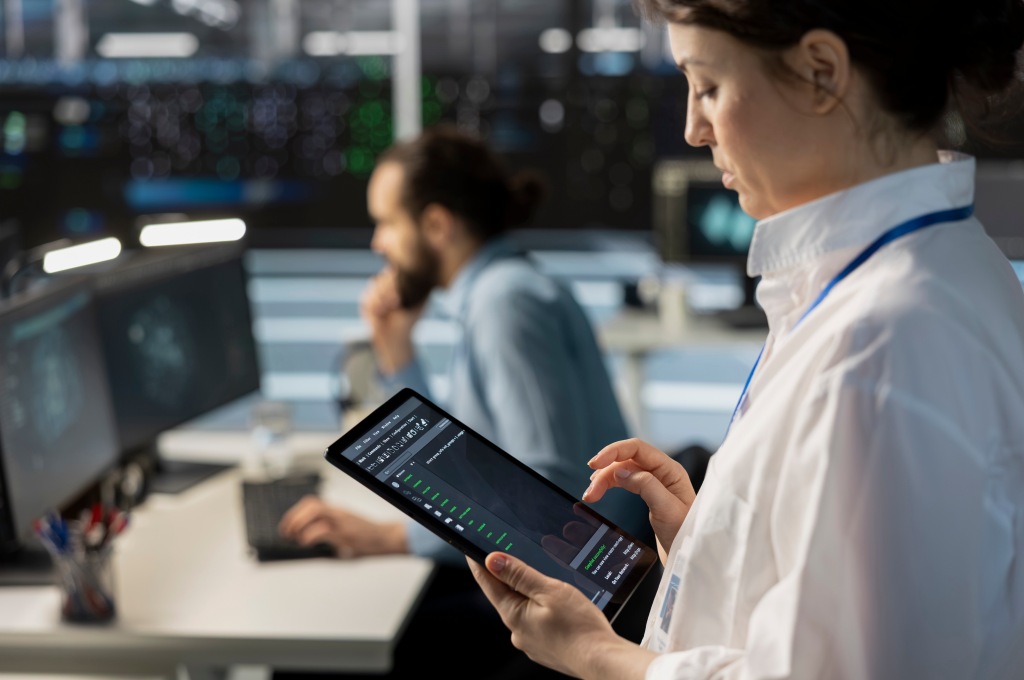 Woman Monitoring Data on Tablet in High-Tech Control Room