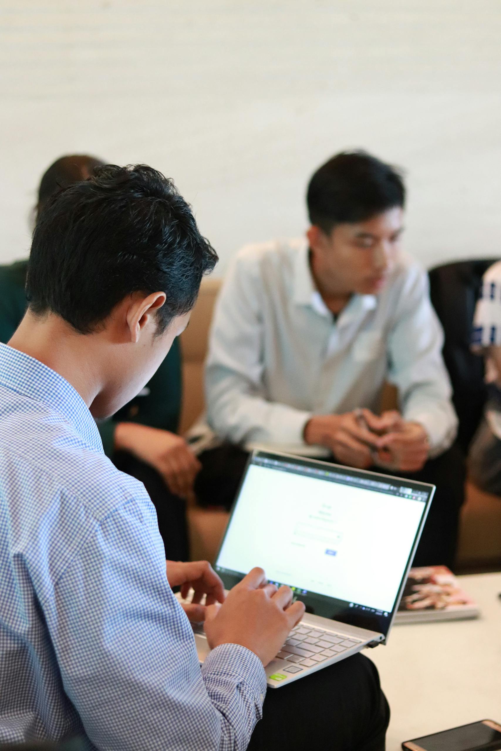 A group of colleagues in a business meeting using laptops for planning and teamwork.