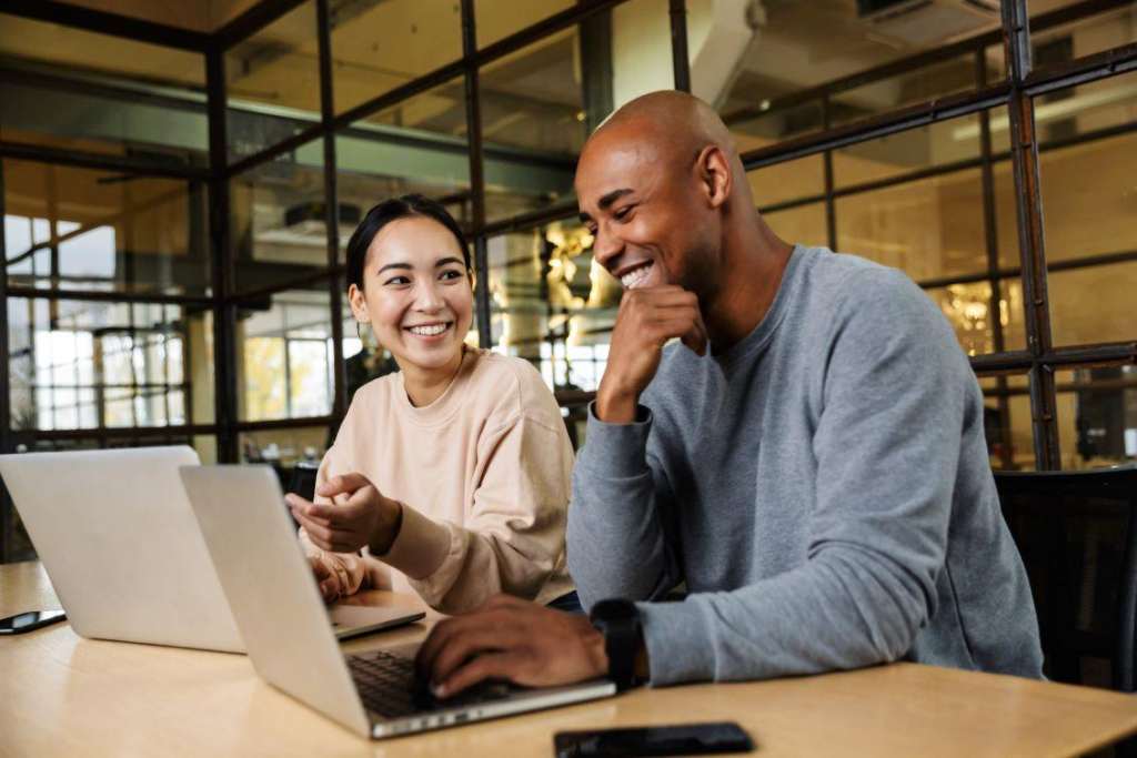 a black man and an asian girl working on a laptop