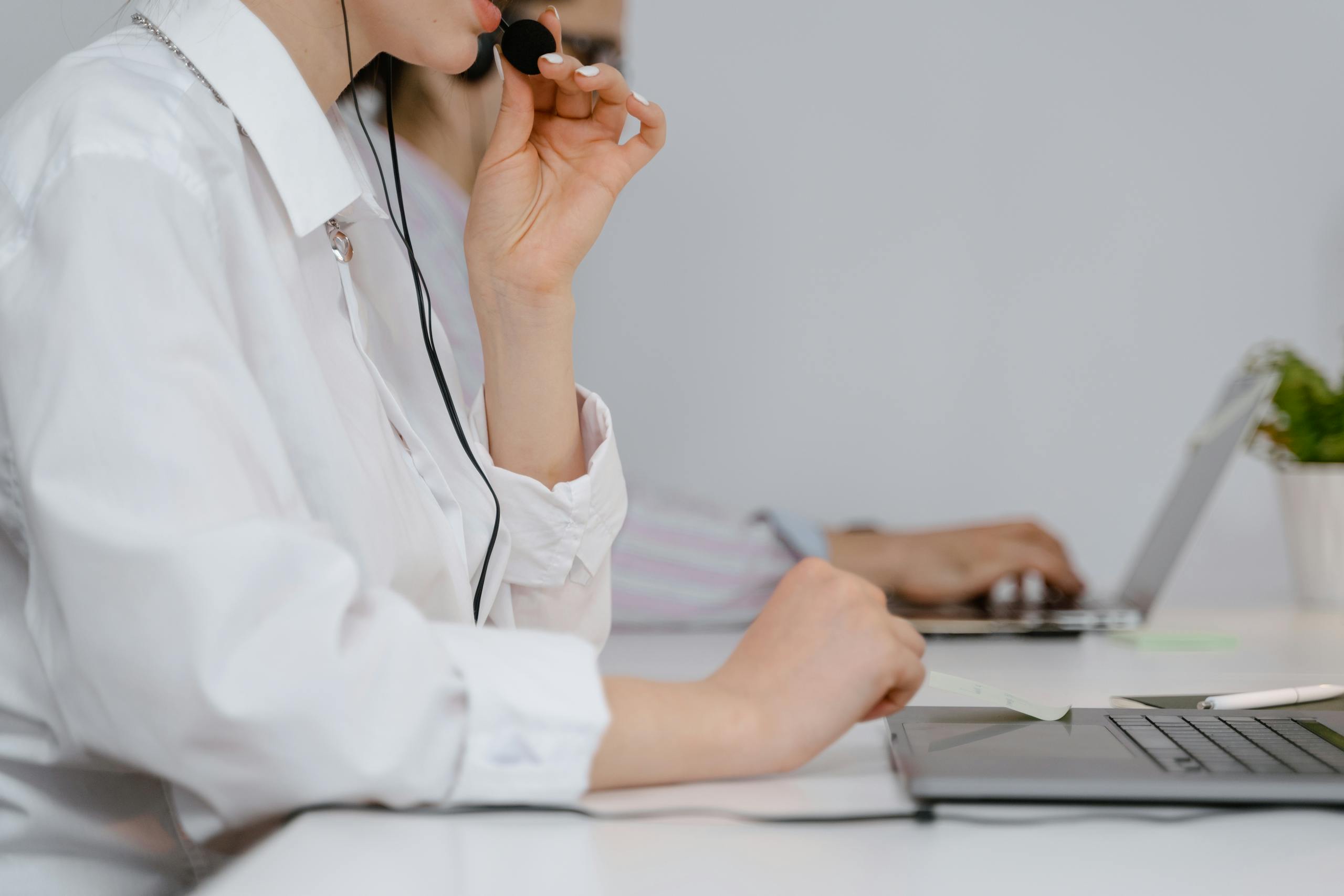 A focused call center professional using a headset at work in an office setting.