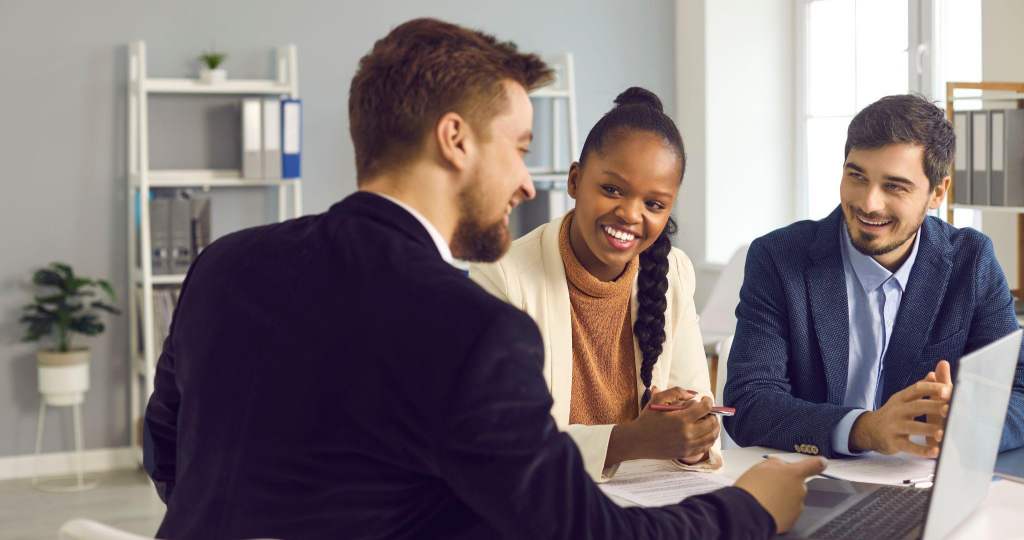 three colleagues discussing the information provided on a laptop