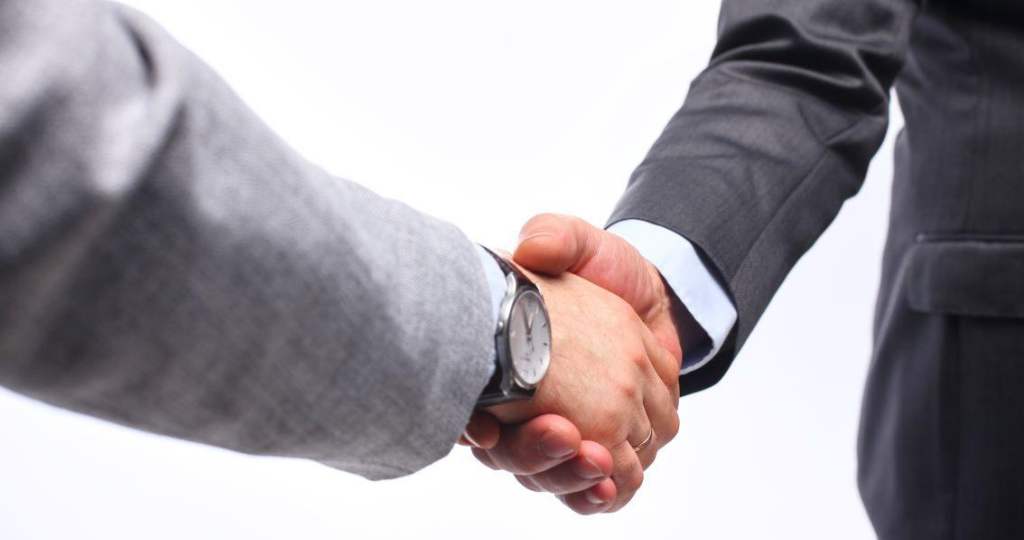 two people in suits shaking hands