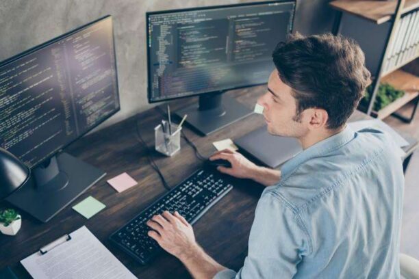 young male developer writing code at his desk