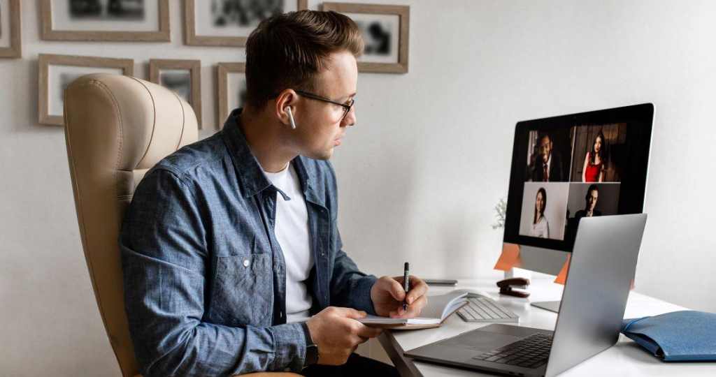 young man sitting at a desk in an online meeting