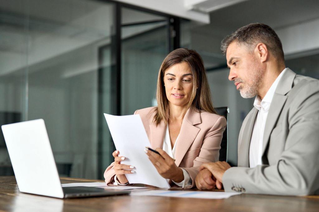 two colleagues reviewing some paperwork in a meeting room