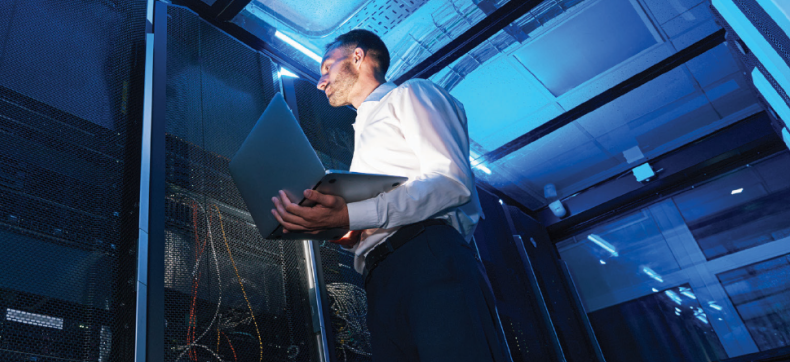 IT specialist inspecting server racks in a blue-lit data center