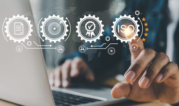 Person interacting with virtual ISO certification icons on laptop screen