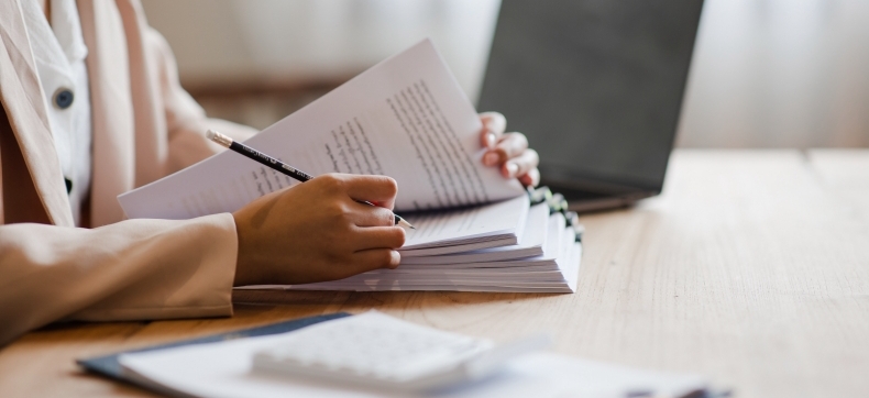 Person reviewing documents at desk with tablet