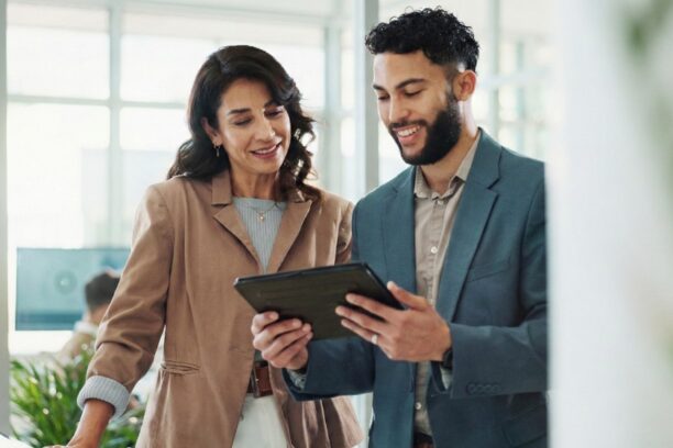 Two IT professionals collaborating over a tablet in a modern office