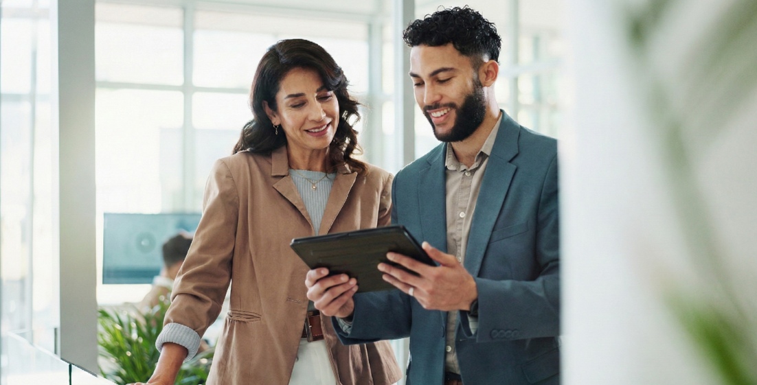 Two IT professionals collaborating over a tablet in a modern office