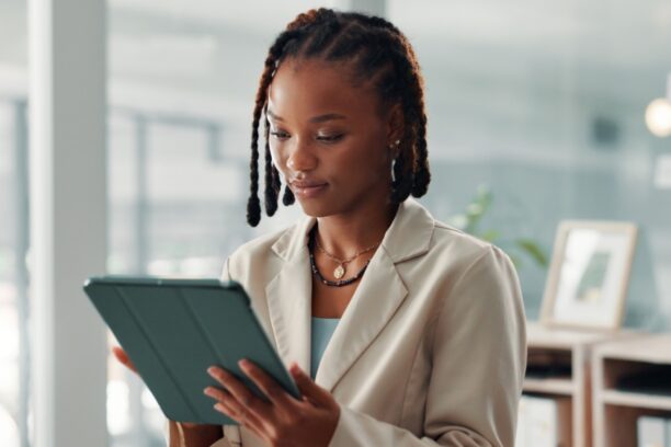 Professional Woman Reviewing Tablet in Modern Office