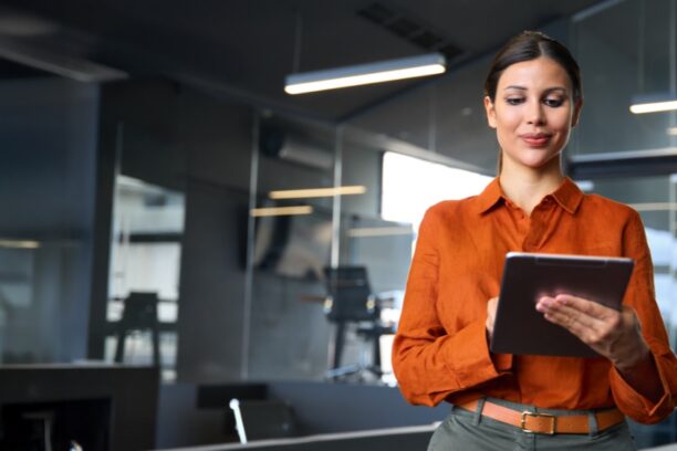 Woman in office reviewing cybersecurity roles on a tablet