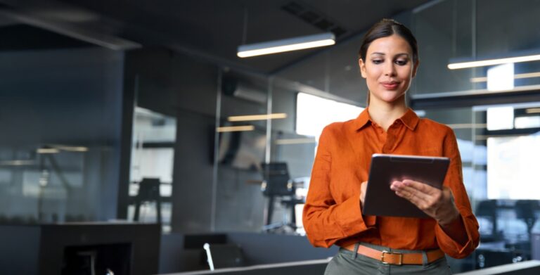 Woman in office reviewing cybersecurity roles on a tablet