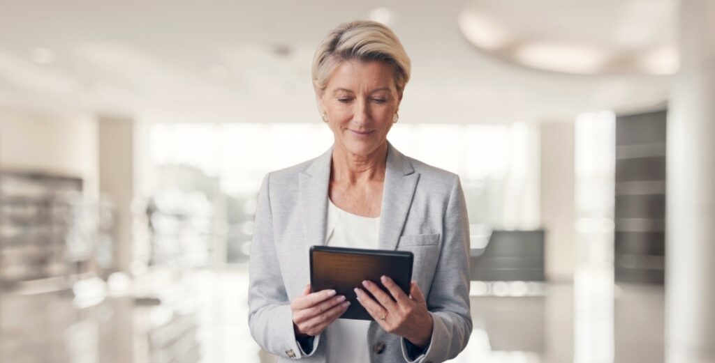 Business professional woman in blazer reviewing information on a tablet