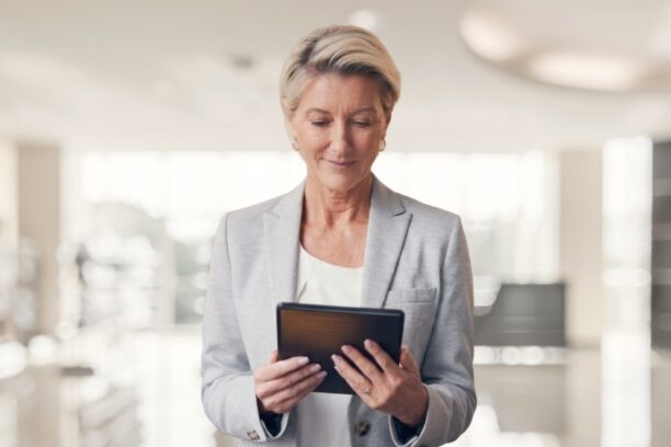 Business professional woman in blazer reviewing information on a tablet