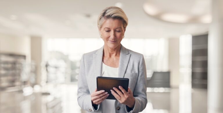 Business professional woman in blazer reviewing information on a tablet