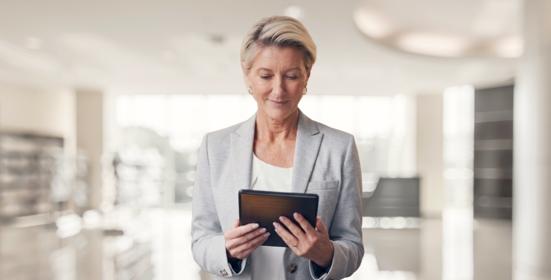 Business professional woman in blazer reviewing information on a tablet