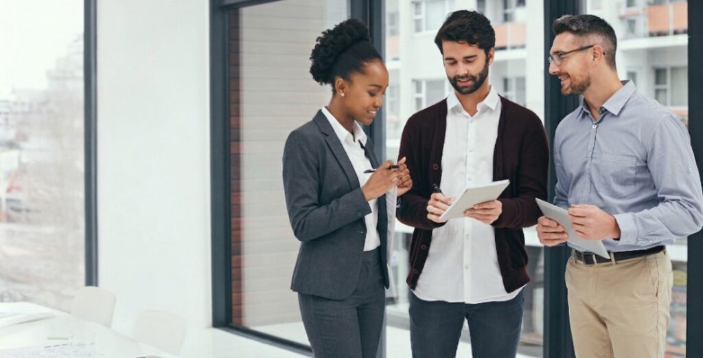 Three business professionals collaborating on app development team strategy